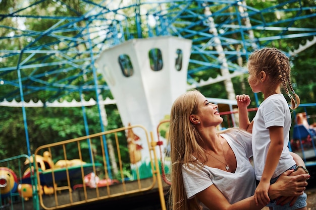 loving each other cheerful little girl her mother have good time park together near attractions 1086199 13897